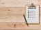 Check list on paper clipboard on wood background