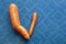 Check mark sign. Fresh curved carrots on blue background. Space for text