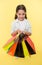 Check out her shopping packages. Child cute shopaholic with bunch shopping bags black friday total sale. Take shopping