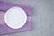 Checked white plate and lilac tablecloth