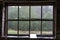 Checked window frame. View of the forest through a window without glass