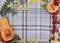 checkered beige autumn background with edible cut pumpkin and crimson yellow leaves