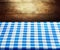 Checkered blue tablecloth over wooden background