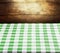 Checkered green tablecloth over wooden background