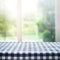 Checkered tablecloth texture top on blur of window and garden