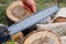 Checking and adjusting the chain tension of the chain saw. A worker checks the tension of the saw chain against a background of