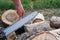 Checking and adjusting the chain tension of the chain saw. A worker checks the tension of the saw chain against a background of