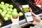 Checking calories on apple in store with smartphone