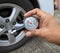 Checking tire air pressure with meter gauge before traveling