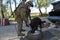 At the checkpoint, training. Military handler and a trained dog searching a wheel of a suspects car