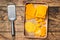 Cheddar Cheese Grated and diceded in a wooden tray. wooden background. Top view