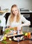 Cheeful woman putting pieces of fish in frying pan