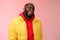 Cheeky stylish funny african bearded man in yellow trendy jacket red hoodie show tongue sassy flirty gaze winking camera