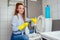 Cheereful redhaired ginger woman washing in rest room toilet wearing gloves