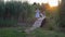 Cheerful active child girlfriends run and play on wooden bridge among green high reeds in open air