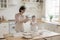 Cheerful active grandma and happy kid having fun in kitchen