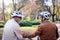 Cheerful active senior couple with bicycle in public park together having fun. Perfect activities for elderly people. Happy mature