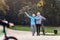 Cheerful active senior couple with bicycle walking in the park