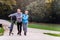 Cheerful active senior couple with bicycle walking in the park