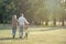 Cheerful active senior couple with bicycle walking through park together. Perfect activities for elderly people in retirement