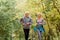 Cheerful active senior couple jogging in the park