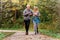 Cheerful active senior couple jogging in the park