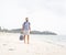 Cheerful adult man with bag having fun on tropical beach