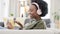 Cheerful african afro woman using phone and headphones and waving while on a video call with friends. Remote student