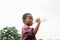 Cheerful african american boy drinking water after playing at park