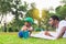Cheerful african american father and son playing in park, parent and childs drawing and painting in the park, Happiness family