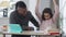 Cheerful African American teen daughter giving high-five to smiling father helping student with homework at home
