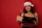 Cheerful African American woman with beautiful toothy smile, holds Christmas gift boxes wrapped in glitter red green gift paper