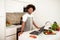 Cheerful African Man At Laptop Navigating Digital Recipes Cooking Indoor