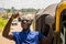 cheerful african man winner holding a key celebrating and jubilant standing next to an auto rickshaw taxi outdoor