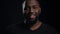 Cheerful afro guy posing indoors. African man staring at lens in studio