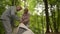 Cheerful aged couple setting up the tent in the wood