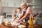 Cheerful aging lady and focused boy cooking in the kitchen