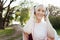 Cheerful aging woman enjoying music in headphones outdoors