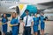 Cheerful aircrew with travel bags standing outdoors in airfield