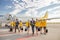 Cheerful aircrew with travel bags walking down the airfield