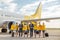 Cheerful aircrew with travel suitcases walking down the airfield