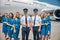 Cheerful airline workers or aircrew standing outdoors in airfield