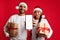 Cheerful Arab Couple Holding Christmas Presents And Showing Blank Smartphone