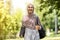 Cheerful arab girl in headscarf holding laptop and coffee