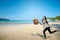 Cheerful asian businesswoman with briefcase going vacation to the beach