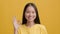 Cheerful Asian Female Gesturing Okay Smiling To Camera, Yellow Background