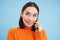 Cheerful asian girl talks on mobile phone, speaks with someone on telephone, stands over blue background