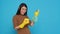 Cheerful asian housewife wearing rubber gloves while cleaning house using sponge and detergent spray