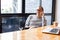 Cheerful asian male small business owner talking on phone with customer while sitting in office. Copy space.