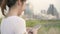 Cheerful Asian tourist blogger woman using touchscreen technology at smartphone while walking on the street.